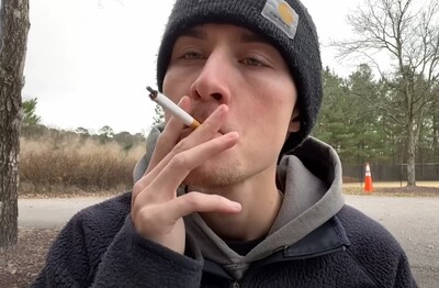 Лечение зависимости от табакокурения в ЗелАО Москвы Мужчина с сигаретой делает затяжку